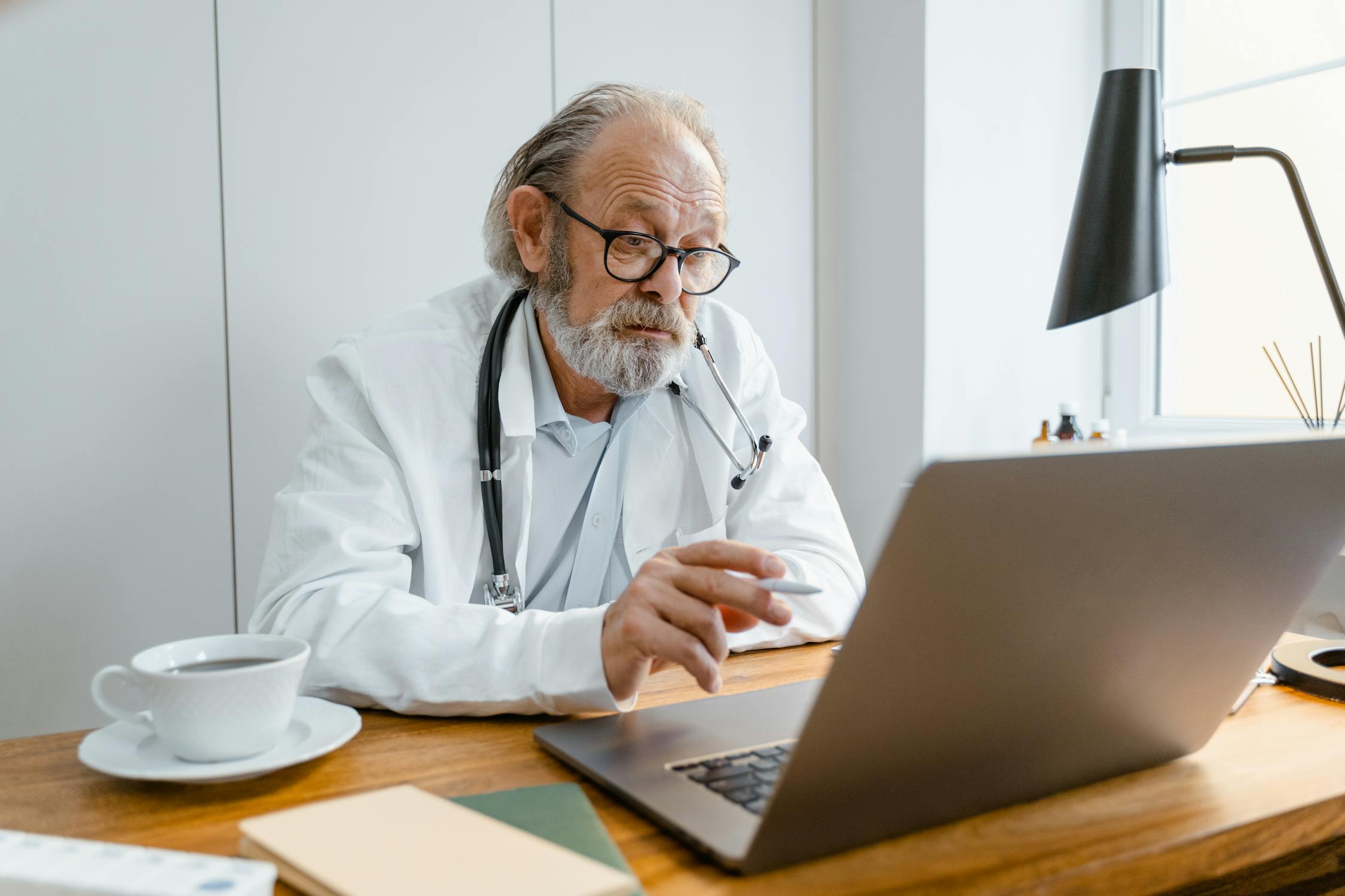 Physician reviewing clinical AI data on laptop